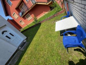 una mesa y una silla azul en un patio en Garsonjera u centru Prnjavor en Prnjavor