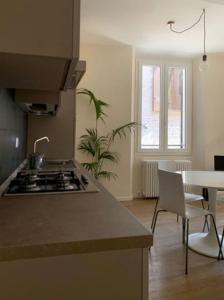 a kitchen with a stove and a table and a dining room at Appartamento centro storico Nuovo e Ristrutturato in Pesaro