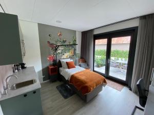 a bedroom with a bed and a sink and a window at Gasthuis Sanitatem in Putten