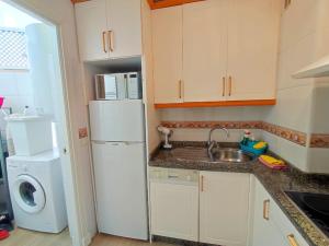 eine Küche mit einem weißen Kühlschrank und einer Spüle in der Unterkunft Penthouse in Puerto Marina Benalmádena in Benalmádena