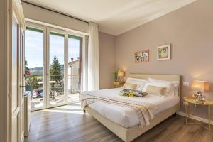 a bedroom with a large bed and a balcony at B&B La Cornice in San Gimignano