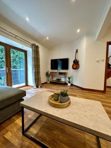 Una sala de estar con un sofá y un televisor en 4 Sheraton Apartments, en Fort William