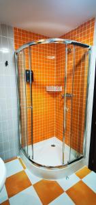 y baño con ducha y azulejos de color naranja. en APARTAMENTO ALES II, en Arenas de San Pedro