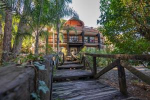 a house with a wooden bridge in front of it at Carilo Village Apart Hotel & Spa in Carilo