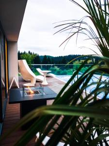 a living room with a table and chairs on a deck at Silver Mountain Resort & Spa in Poiana Brasov