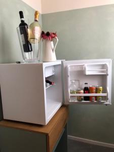 an open refrigerator with bottles of wine on top of a counter at B&B MELLONI STREET in Dolo