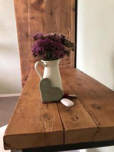 a vase filled with purple flowers on a wooden table at B&B MELLONI STREET in Dolo