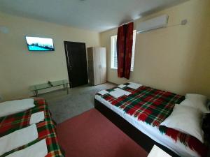 a bedroom with two beds and a tv on the wall at Viriks in Burgas