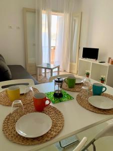 une table avec des assiettes et des tasses en haut dans l'établissement Casa vacanza La Cuphea, à Marina di Ragusa