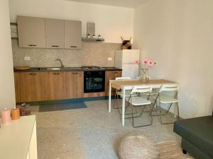 een keuken met een tafel en stoelen en een koelkast bij Casa vacanza La Cuphea in Marina di Ragusa