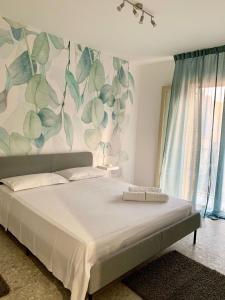 - une chambre avec un grand lit et un mur fleuri dans l'établissement Casa vacanza La Cuphea, à Marina di Ragusa