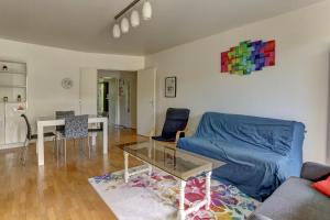 sala de estar con sofá azul y mesa en Le Montespan- Saint Cyr, en Saint-Cyr-lʼÉcole