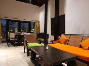 a living room with a couch and chairs and a table at The Royal Beach Seminyak Bali in Seminyak