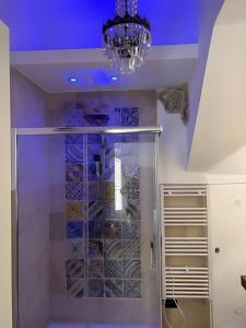 bagno con doccia in vetro e lampadario pendente di La Dimora Degli Angeli a Noto