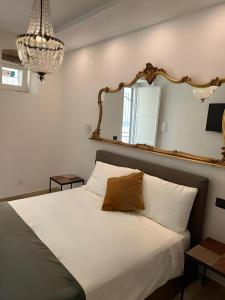 una camera da letto con un grande letto bianco e uno specchio di La Dimora Degli Angeli a Noto