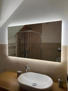 un bagno con un lavandino e un grande specchio di La Dimora Degli Angeli a Noto Altre 20 foto