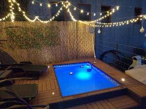 einen Pool auf einer Terrasse mit Beleuchtung und einem Tisch in der Unterkunft Appartamento vista lago in Sulzano