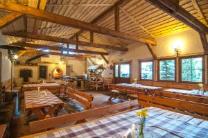 una grande sala da pranzo con tavoli e panche in legno di Hotel Pod Szrenicą a Szklarska Poręba