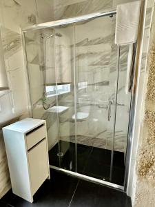 y baño con ducha con cabina de ducha de cristal. en Guest house D. Filipe I, en Oporto