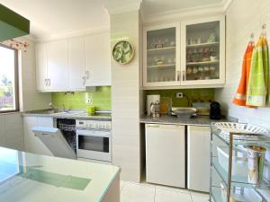 a kitchen with white cabinets and a counter top at Vilamoura Central 7 With Pool by Homing in Vilamoura