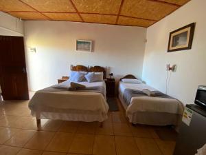 a hotel room with two beds and a tv at El-Kole Bed and Breakfast in Tsumeb