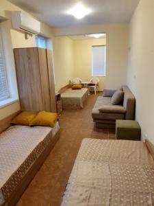 a room with two beds and a couch and a room with at Viriks in Atanasovo