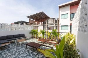 a patio with a couch and chairs on a building at Cozy Patong Beach House 3 Bedrooms in Patong Beach