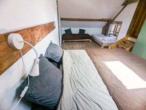 a bedroom with a bed and a couch in a room at LES REPAIRES in Nans-sous-Sainte-Anne