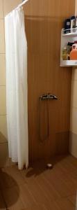 a shower with a white shower curtain in a bathroom at Viriks in Atanasovo