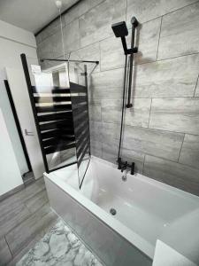 a bathroom with a shower and a bath tub at Hackney Haven! in London