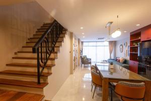 a living room with a staircase and a dining room at Cozy Patong Beach House 3 Bedrooms in Patong Beach
