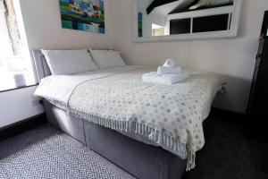Un dormitorio con una cama con una toalla. en Idyllic Cornish cottage in the beautiful Lamorna valley - walk to pub & sea, en Paul