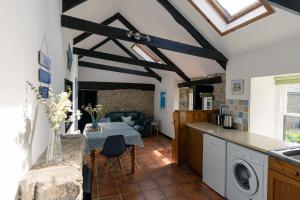 a kitchen with a table and a dining room at Idyllic Cornish cottage in the beautiful Lamorna valley - walk to pub & sea in Paul