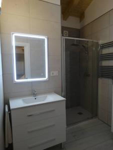 y baño con lavabo y ducha con espejo. en Apartamentos Les Texuques en Nueva de Llanes