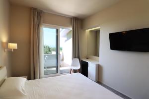 una camera d'albergo con un letto e una grande finestra di Borgo San Cosmo Tropea a Brattirò