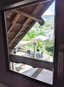 a view of a patio through a window at LES REPAIRES in Nans-sous-Sainte-Anne +23 photos