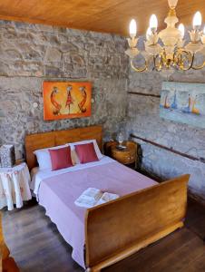 ein Schlafzimmer mit einem großen Bett in einer Steinmauer in der Unterkunft Chora Samothrakis, House with courtyard in Samothráki