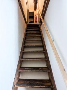 una antigua escalera de madera en una habitación con una pared blanca en LES REPAIRES, en Nans-sous-Sainte-Anne