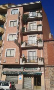 a tall brick building with windows and balconies at Hostal Avenida in Benavente