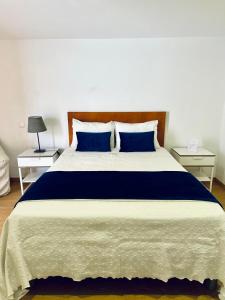 a bedroom with a large bed with blue pillows at Guest house D. Filipe I in Porto
