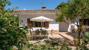 una casa bianca con un ombrellone in giardino di Houm Villa Nets a Playa de Palma