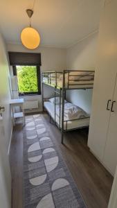 RämshyttanにあるRämsbyns Fritidsbyの二段ベッド2台とラグが備わる客室です。