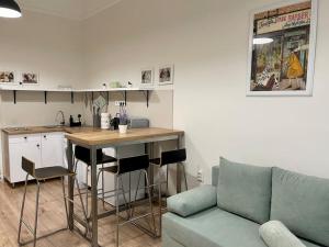 a living room with a couch and a kitchen with a table at DIZURA Apartments Szeged in Szeged