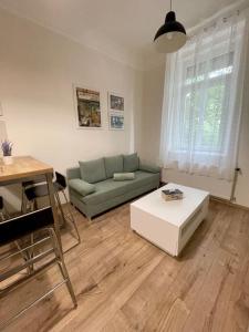 a living room with a couch and a coffee table at DIZURA Apartments Szeged in Szeged