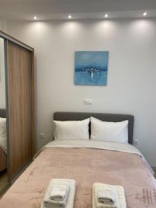 una camera da letto con un grande letto con due cuscini bianchi di Elysian - AT067 ad Atene