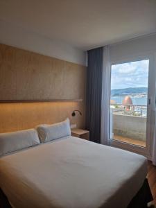 sypialnia z dużym łóżkiem i oknem w obiekcie Hotel Maroa Vigo w mieście Vigo