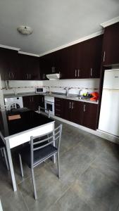 - une cuisine avec une table et un banc dans l'établissement Apartamento terra1, à Caldas de Reis