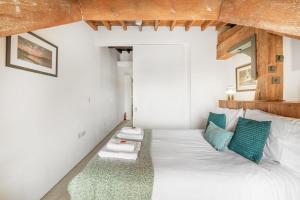 a bedroom with a white bed with green pillows at Luxury 2 bed Apartment in historic Royal William Yard in Plymouth +33 photos