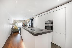 a kitchen with white cabinets and a counter top at Luxury 2 bed Apartment in historic Royal William Yard in Plymouth
