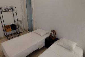2 Betten in einem Zimmer mit weißen Wänden in der Unterkunft Apartamento al lado del Museo DalÍ in Figueres